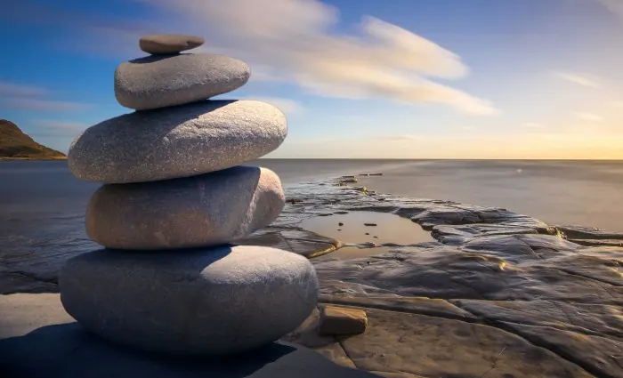 Galets en équilibre au bord de l'eau, symbole de l'équilibre retrouvé grâce au magnétisme