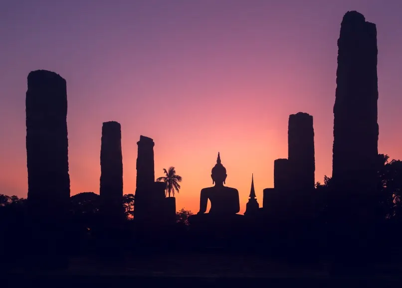 Silhouette méditative devant un coucher de soleil, symbole de l'harmonisation énergétique